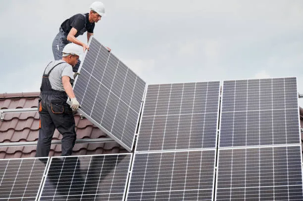 Hombres instalando tipos de paneles solares en el techo, asegurando la correcta colocación para maximizar la eficiencia de generación de energía.