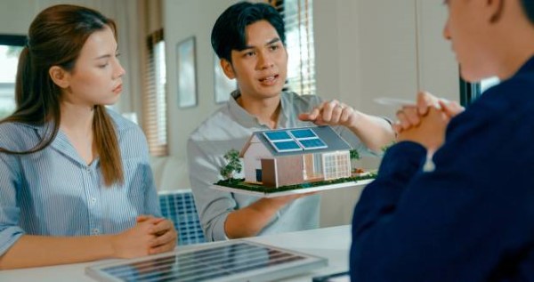 2.cotización de paneles solares; joven con una maqueta de una cada que tiene un panel