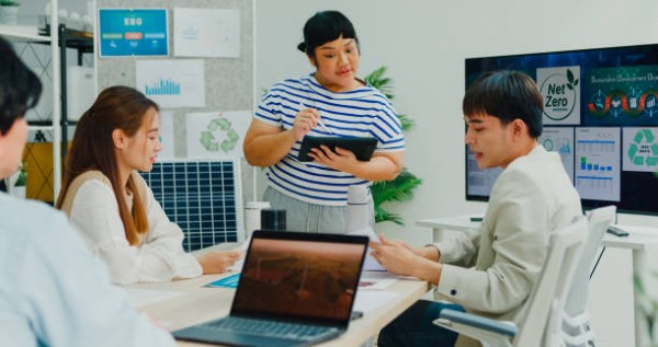 Tres personas discutiendo sobre paneles solares, informándose sobre el FIDE y sus beneficios para proyectos sostenibles