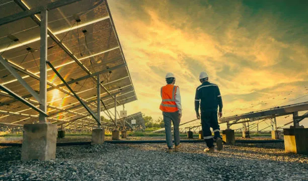 Dos personas caminando junto a una instalación activa que integra inversores solares