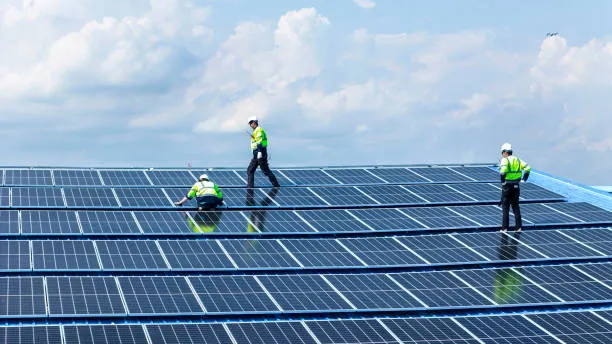 Ingeniero especializado revisando módulos fotovoltaicos instalados en la azotea de una nave industrial, ejemplo de mantenimiento de paneles solares en Zapopan.