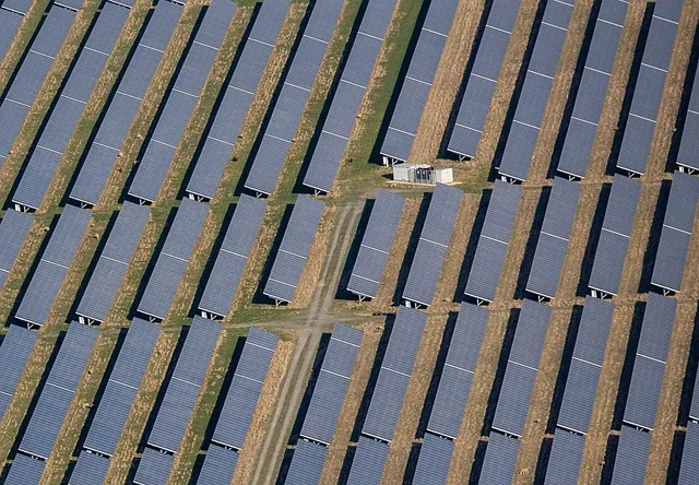 Vista aérea de un conjunto de paneles solares alineados bajo el sol, representando visualmente cómo sé cuánta energía están generando mis paneles solares.