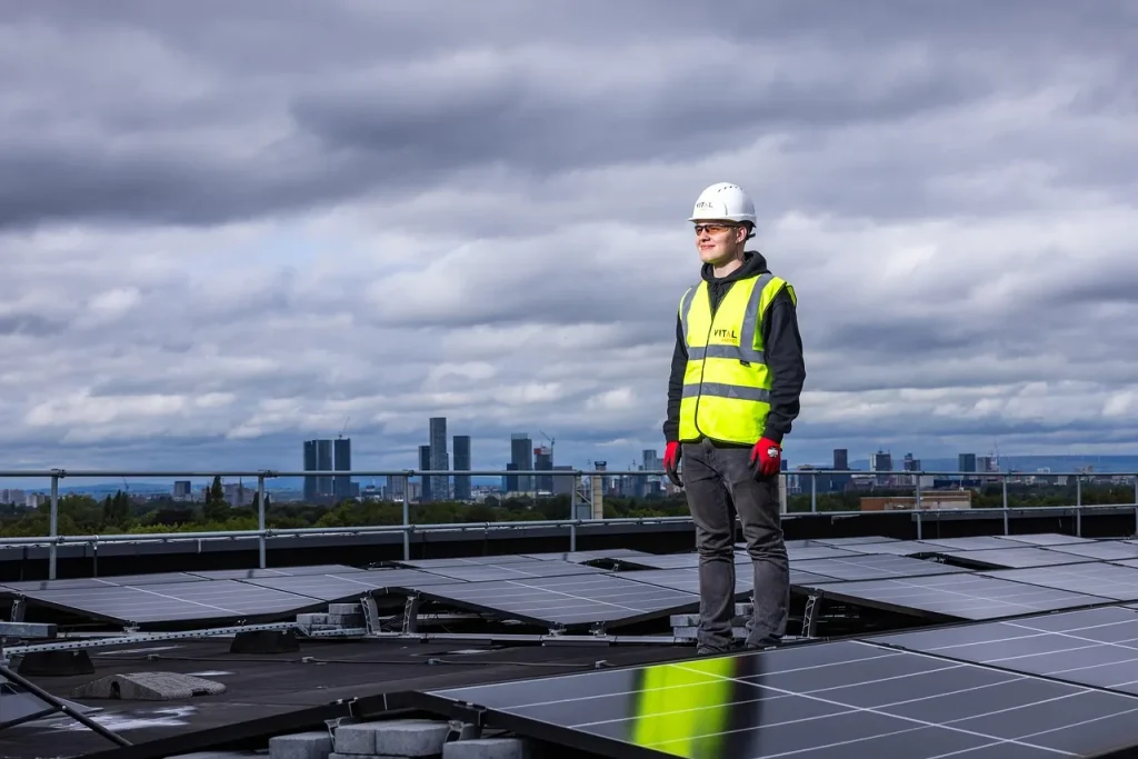 Mujer profesional de negocios revisando la calidad y el estado de la instalación de los grandes paneles solares en un tejado comercial, demostrando la confianza de saber ¿Qué tipo de garantía tienen mis paneles solares y el inversor? para sus activos.
