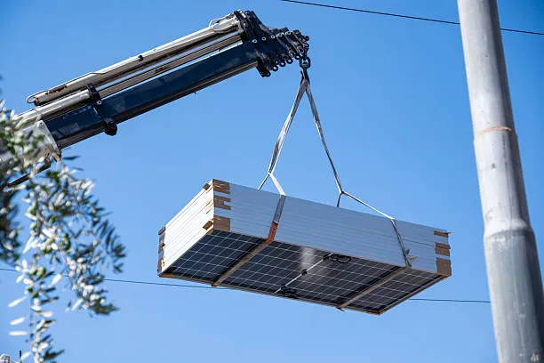 Maquinaria especializada transportando varios paneles solares de forma segura para una reubicación eficiente durante una mudanza ¿Qué pasa si me cambio de casa, puedo llevarme los paneles?