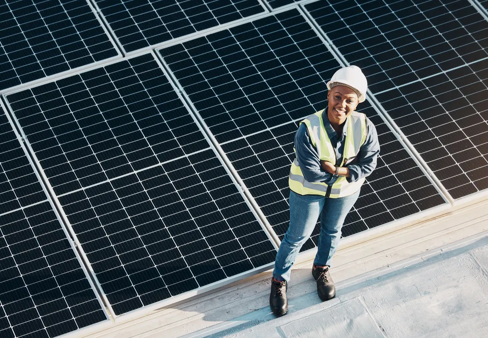 Mujer ingeniera destaca las ventajas de los paneles solares de alta eficiencia instalados en techos de edificios urbanos.
