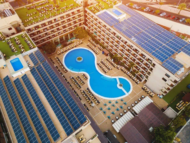 Fotografía aérea de un gran hotel que cuenta en sus techos con paneles solares para negocio