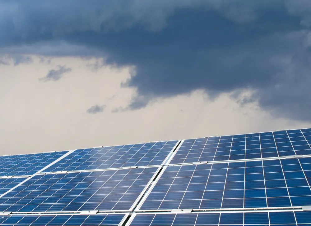 Arreglo de paneles solares fotovoltaicos captando radiación difusa bajo el cielo para mantener la producción.
