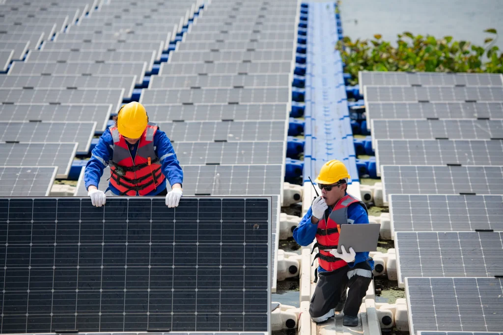 Especialistas con chalecos de seguridad de la Asociación Mexicana Industria Fotovoltaica revisando sistemas fotovoltaicos sobre el agua para optimizar el rendimiento.