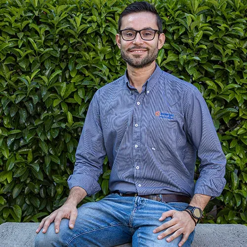 Enrique Elizondo, del departamento de ingeniería de una empresa de paneles solares, sentado con camisa azul clara.