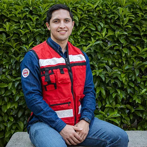 Omar García, especialista en ventas de una empresa de paneles solares, con chaleco de seguridad rojo en exteriores