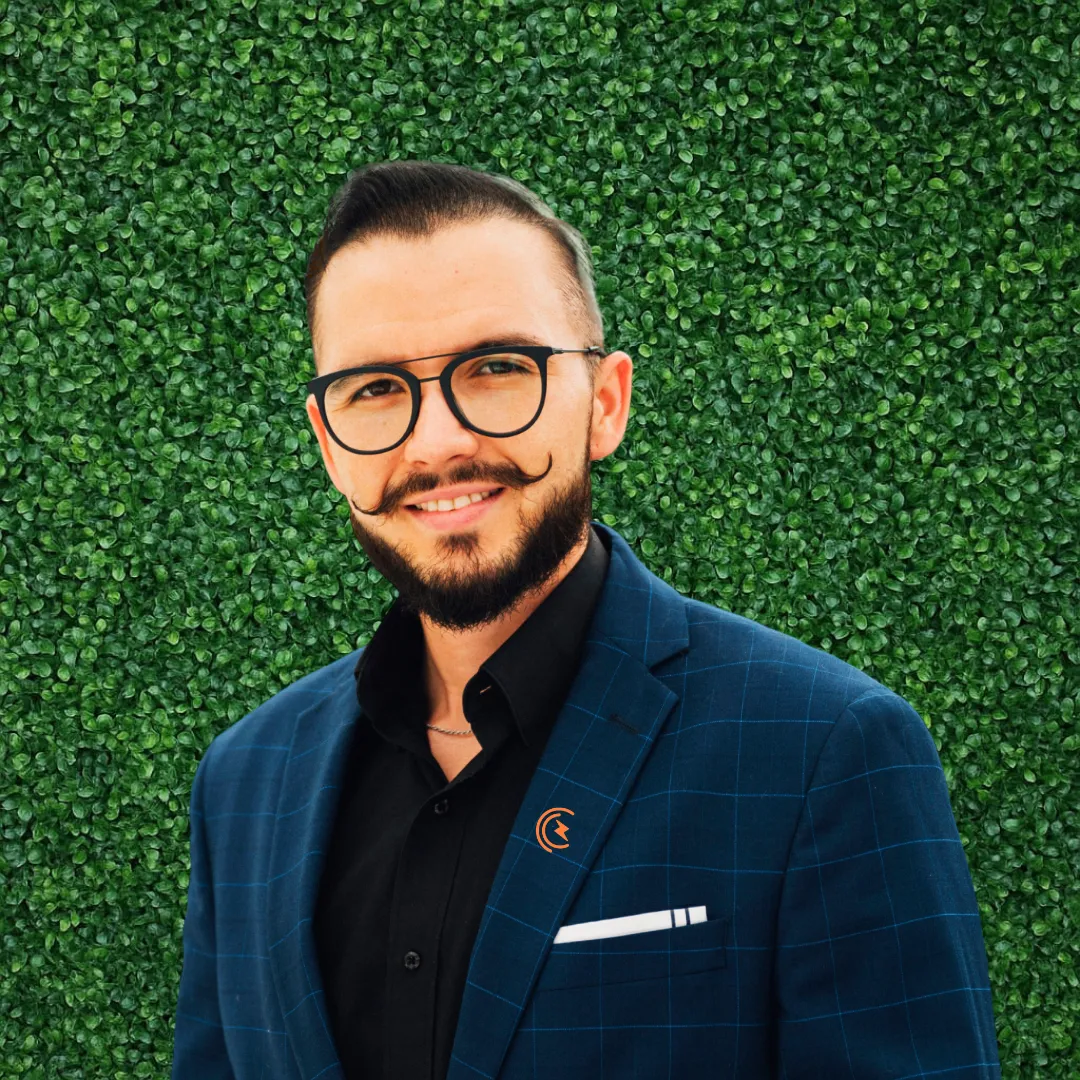 Zayn Garnica, ejecutivo de ventas de una empresa de paneles solares, vistiendo saco azul y camisa negra formal.